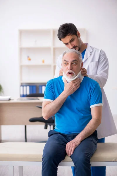 Alter Hals verletzt männliche Patientin besucht junge männliche Ärztin — Stockfoto