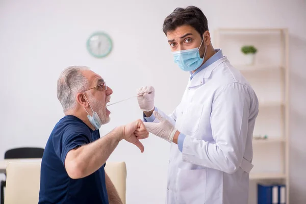 Old male patient visiting young male doctor otorhinolaryngologis — Stock Photo, Image