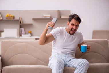 Genç erkek öğrenci salgın sırasında evde oturuyor.