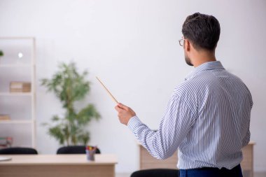 Sınıftaki genç erkek öğretmen.