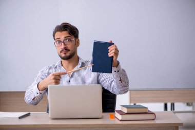 Sınıftaki genç erkek öğretmen.