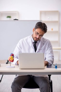 Sınıfta oturan genç erkek kardiyolog.