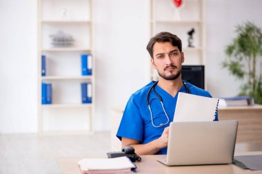 Klinikte çalışan genç erkek doktor.