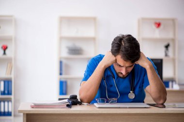 Klinikte çalışan genç erkek doktor.