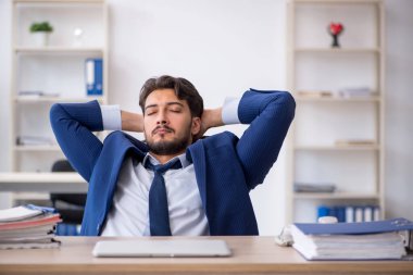 Genç erkek çalışan ofiste çok yorgun.