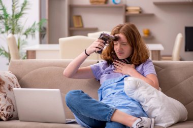 Evde acı çeken genç bir kadın.