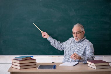 Sınıftaki yaşlı erkek öğretmen.