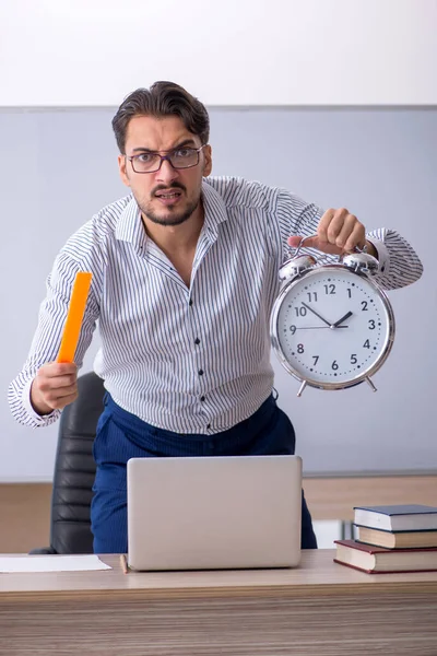Fiatal férfi tanár az időgazdálkodás koncepciójában — Stock Fotó
