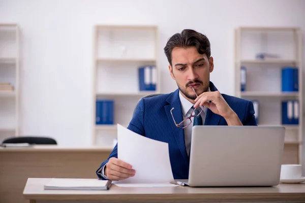 Jonge mannelijke werknemer werkzaam in het kantoor — Stockfoto