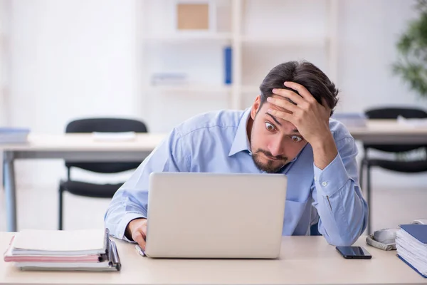 Jonge mannelijke werknemer werkzaam in het kantoor — Stockfoto