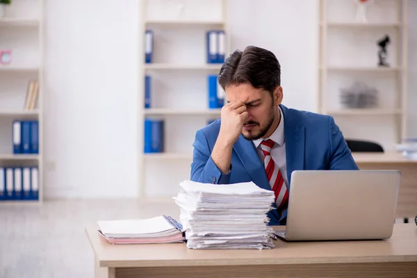 Junge männliche Mitarbeiter und zu viel Arbeit im Büro — Stockfoto