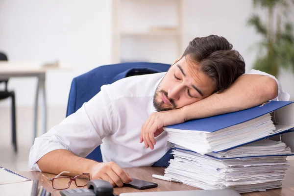 Jovem funcionário masculino infeliz com excesso de trabalho no escritório — Fotografia de Stock