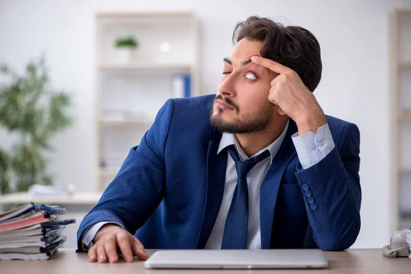 Jonge mannelijke werknemer zeer moe in het kantoor — Stockfoto