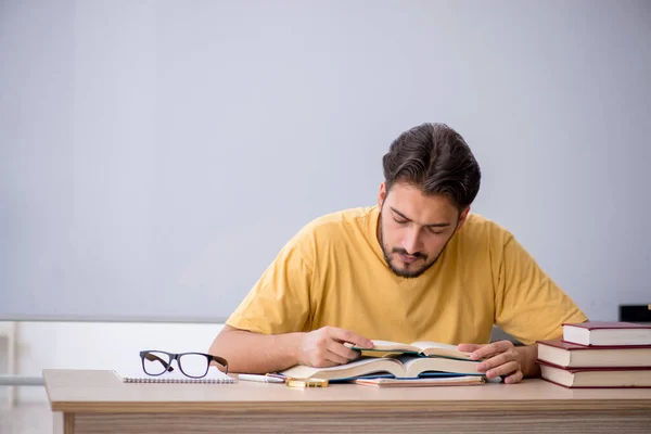 Giovane studente maschio che si prepara per gli esami in classe — Foto Stock