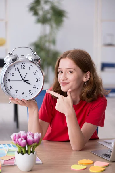 Jonge vrouwelijke ontwerper in time management concept — Stockfoto