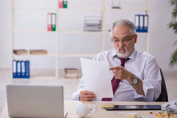 Old drug addicted employee sitting in the office — Stock Photo, Image