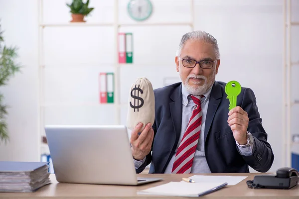 Old male employee in remuneration concept at workplace — Stock Photo, Image