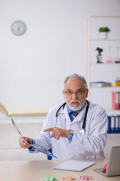 Stary lekarz radiolog pracujący w klinice — Zdjęcie stockowe