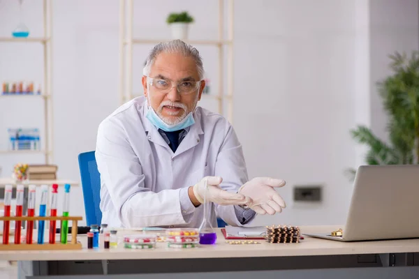 Antiguo químico masculino en concepto de síntesis de fármacos — Foto de Stock