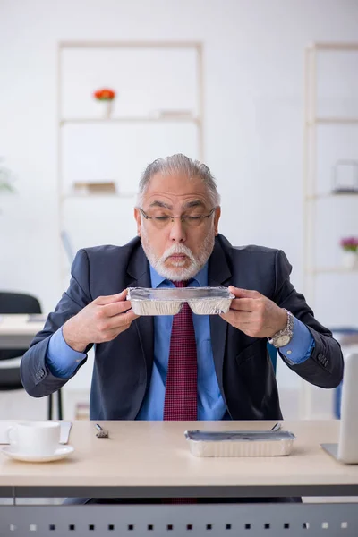 Viejo empleado desayunando en la oficina — Foto de Stock