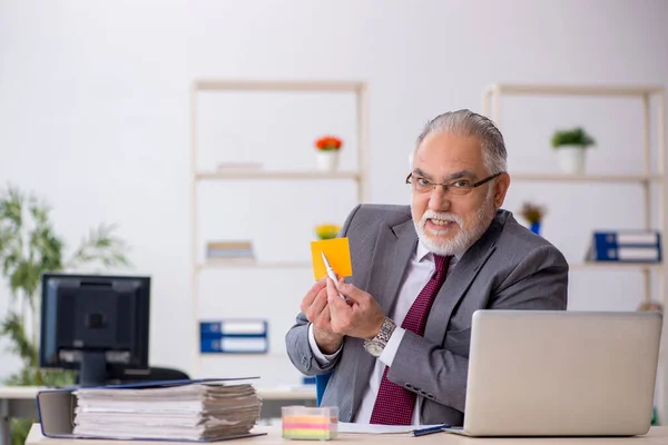 Old male employee sitting in the office — Stock Photo, Image
