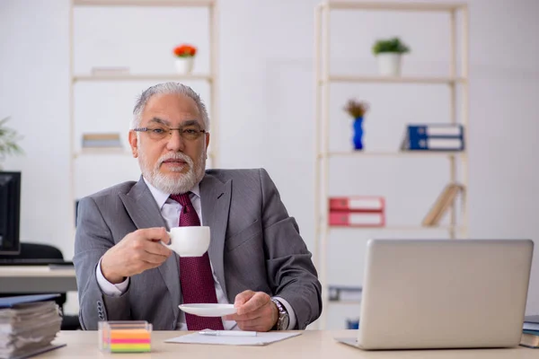 Vecchio dipendente maschio bere caffè durante la pausa — Foto Stock