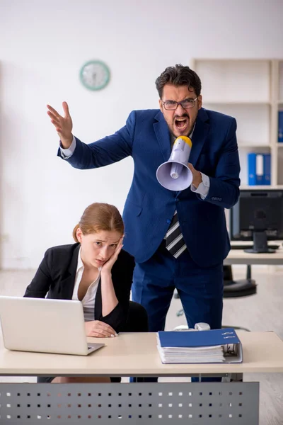 Angry boss and young female employee at workplace — Stock Photo, Image