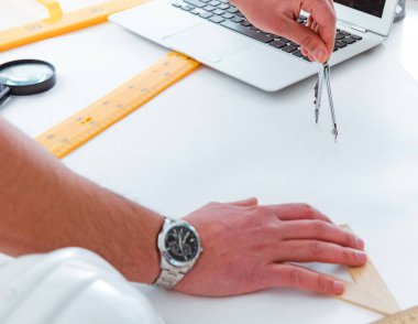 Erkek mühendis çizimler ve planlar üzerinde çalışıyor.