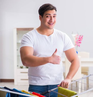 Adam evde çamaşır yıkıyor.