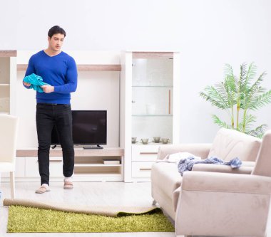 Genç adam çamaşırhane için kirli çamaşır topluyor.