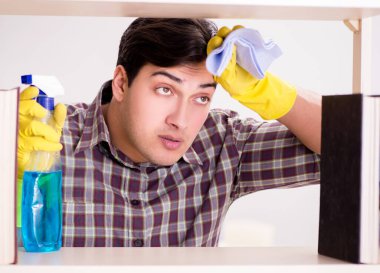 Kitaplıktaki tozları temizleyen adam