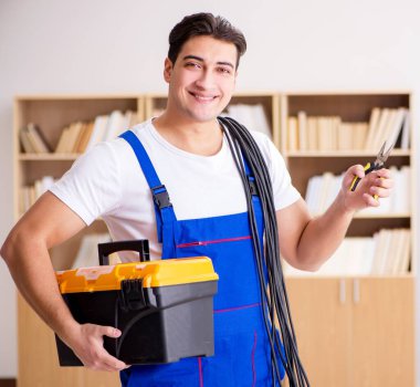 Adam evde elektrik tamiratı yapıyor.