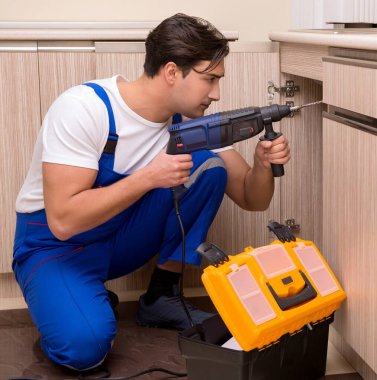 Mutfakta çalışan genç tamirci.