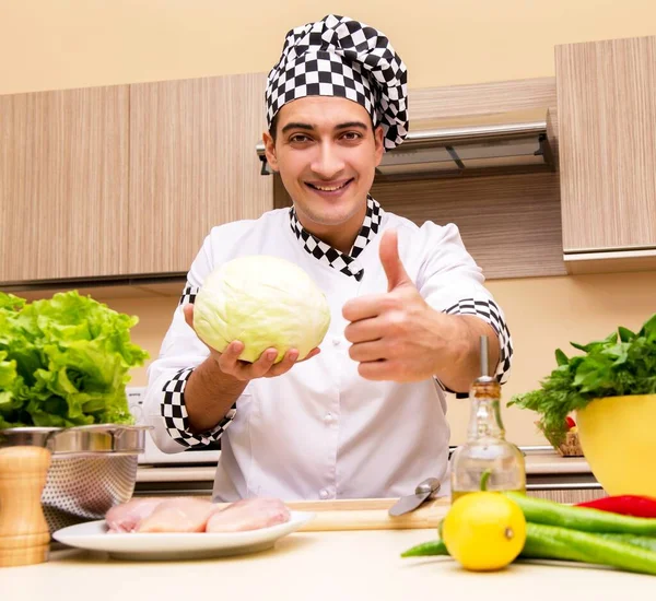 Ung kock som arbetar i köket — Stockfoto