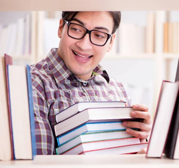 Jovem estudante procurando livros na biblioteca da faculdade — Fotografia de Stock