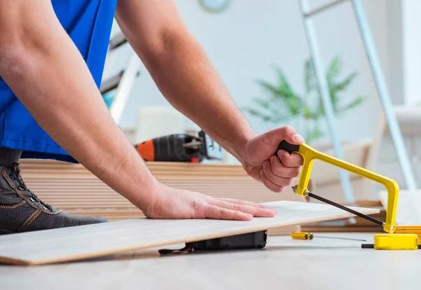 Repairman laying laminate flooring at home — Stock Photo, Image