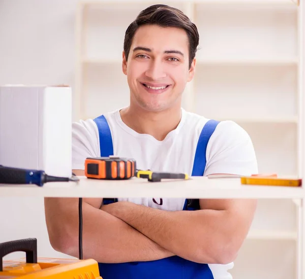 Trabalhador reparando montagem estante de livros — Fotografia de Stock