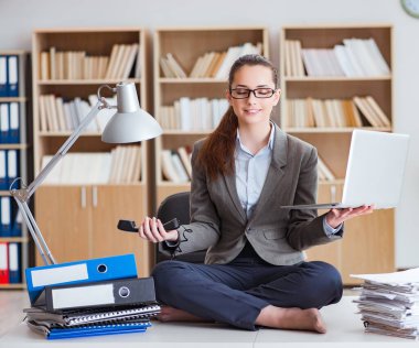 İş kadını ofiste meditasyon yapıyor.