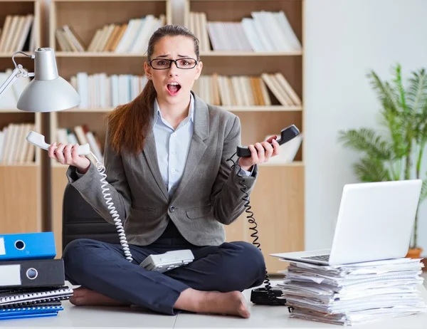 Zaneprázdněná rozzlobená podnikatelka sedící na stole v kanceláři — Stock fotografie