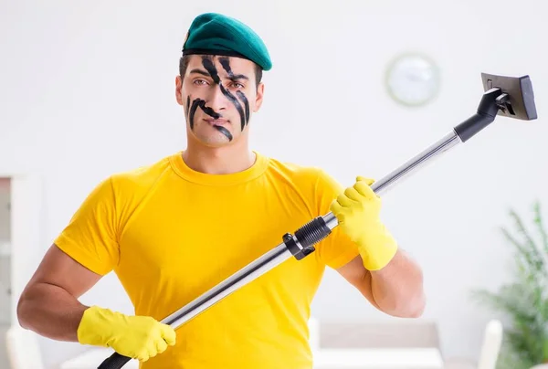 Homem engraçado em estilo militar limpando a casa — Fotografia de Stock