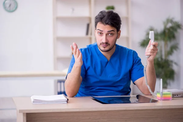 Jonge mannelijke arts werkzaam in de kliniek — Stockfoto