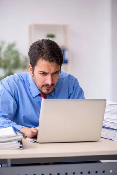 Junge männliche Angestellte unzufrieden mit exzessiver Arbeit im Büro — Stockfoto