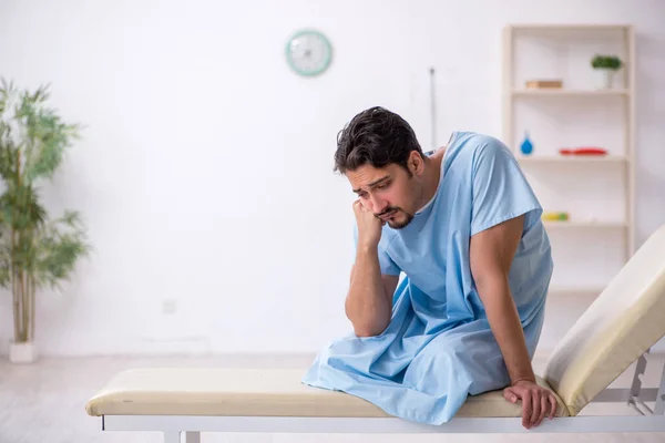 Fiatal férfi beteg várja az orvost a kórházban. — Stock Fotó