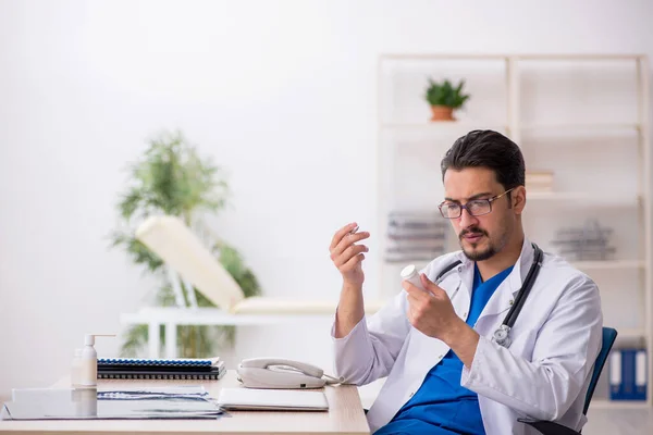 Jonge mannelijke arts suggereert pillen in de kliniek — Stockfoto