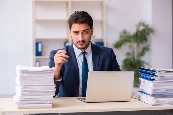 Empleado joven de negocios y demasiado trabajo en la oficina — Foto de Stock