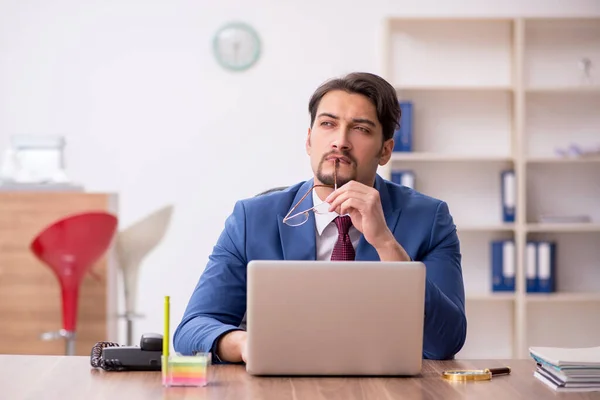 Jovem trabalhador masculino sentado no local de trabalho — Fotografia de Stock