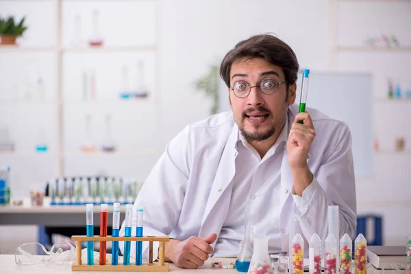Joven químico masculino en concepto de síntesis de fármacos —  Fotos de Stock