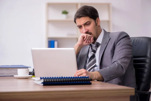 Ung attraktiv manlig anställd sitter på arbetsplatsen — Stockfoto