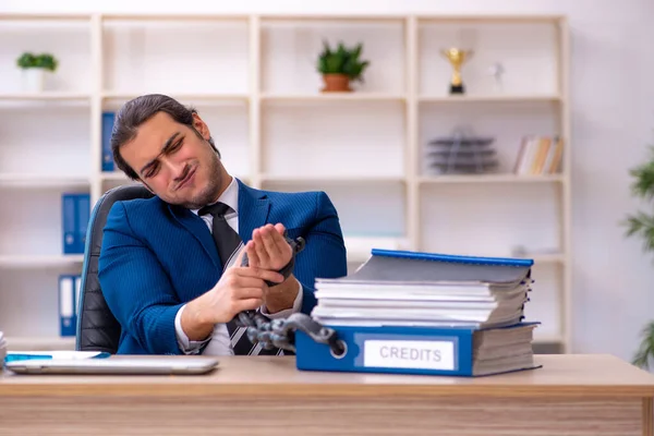 オフィスで過剰な仕事に不満を持つチェーン付き男性従業員 — ストック写真