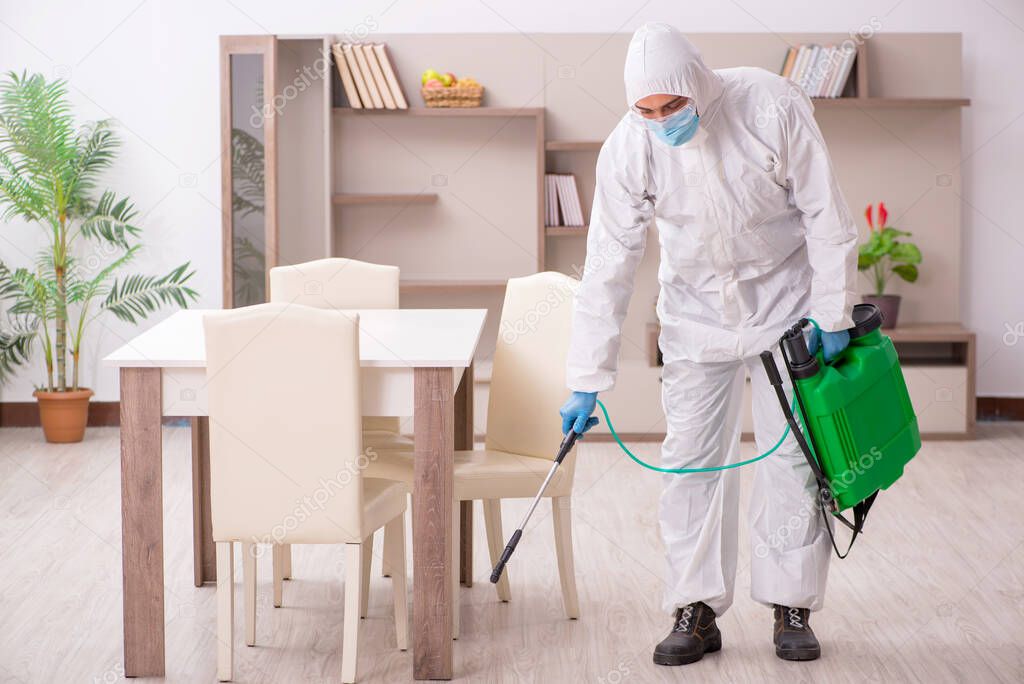Young male contractor disinfecting at home